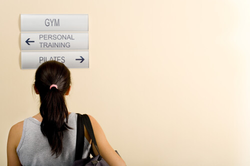 rear-view-of-a-woman-reading-directional-signs-in-a-gym-195417267848e80e405240b.jpeg